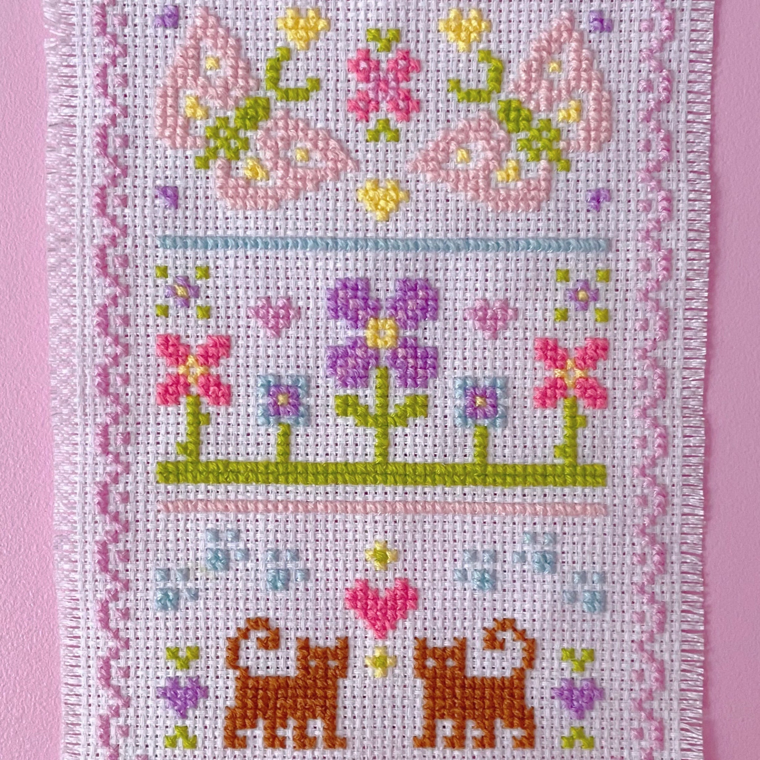 Cross stitch tapestry with butterflies, flowers, and cats